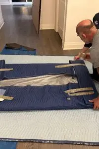 Experienced moving team carefully handling mirror during relocation