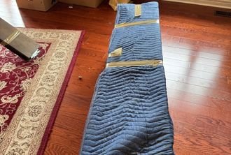 Blue protective floor mats laid down by BMOVED movers to protect hardwood floors during move